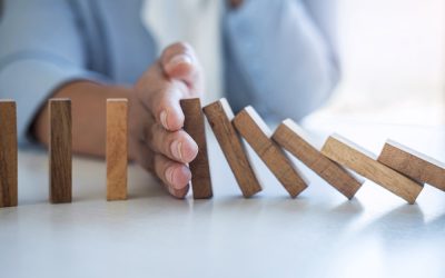 Risk and Strategy in Business, Image of hand stopping falling collapse wooden block dominoes effect from continuous toppled block, prevention and development to stability.
