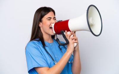 young brazilian nurse woman isolated on white background shouting through a megaphone